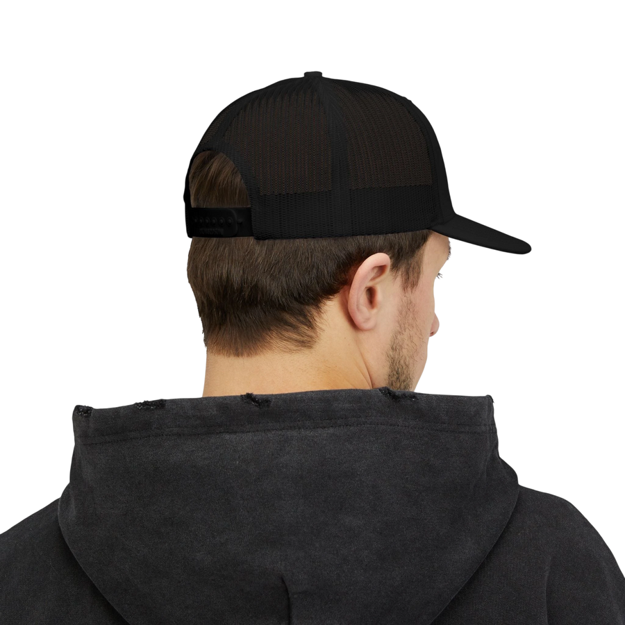 DailyThreadCo. black trucker cap with mesh back worn by a man in a dark hoodie, back view showing snapback closure.