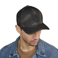 DailyThreadCo. structured FlexFit baseball cap in dark camo print with embroidered logo, worn by a man in denim.