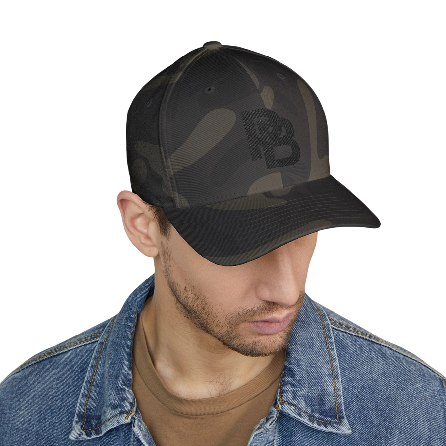 DailyThreadCo. structured FlexFit baseball cap in dark camo print with embroidered logo, worn by a man in denim.