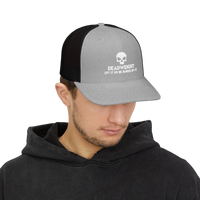 DailyThreadCo. grey and black trucker cap with a white skull Deadweight logo worn by a man in a black hoodie.