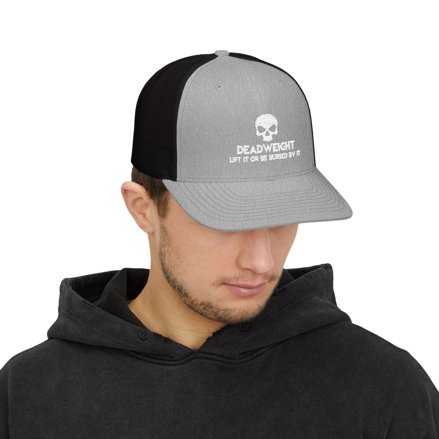 DailyThreadCo. grey and black trucker cap with a white skull Deadweight logo worn by a man in a black hoodie.