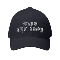 DailyThreadCo. black structured FlexFit cap with white gothic Bang the Iron embroidery on the front panel.