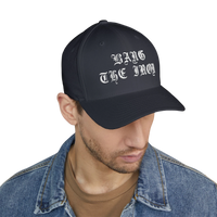 DailyThreadCo. structured FlexFit cap in black with white Bang the Iron gothic embroidery worn by a man.