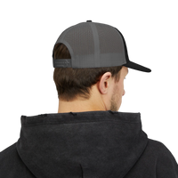 DailyThreadCo. grey and black mesh back trucker cap worn by a man from the back view