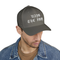 DailyThreadCo. structured grey FlexFit cap with white Bang the Iron gothic embroidery worn by a man in a denim jacket.