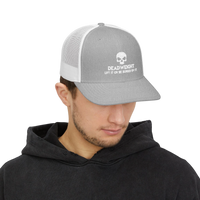 DailyThreadCo. grey and white trucker cap with a skull logo worn by a man in a black hoodie.