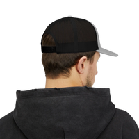 DailyThreadCo. trucker cap with black mesh back and grey brim worn by a man in a dark hoodie, back view.