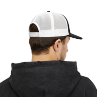 DailyThreadCo. trucker cap with white mesh back and adjustable snapback, worn by a man in a black hoodie.